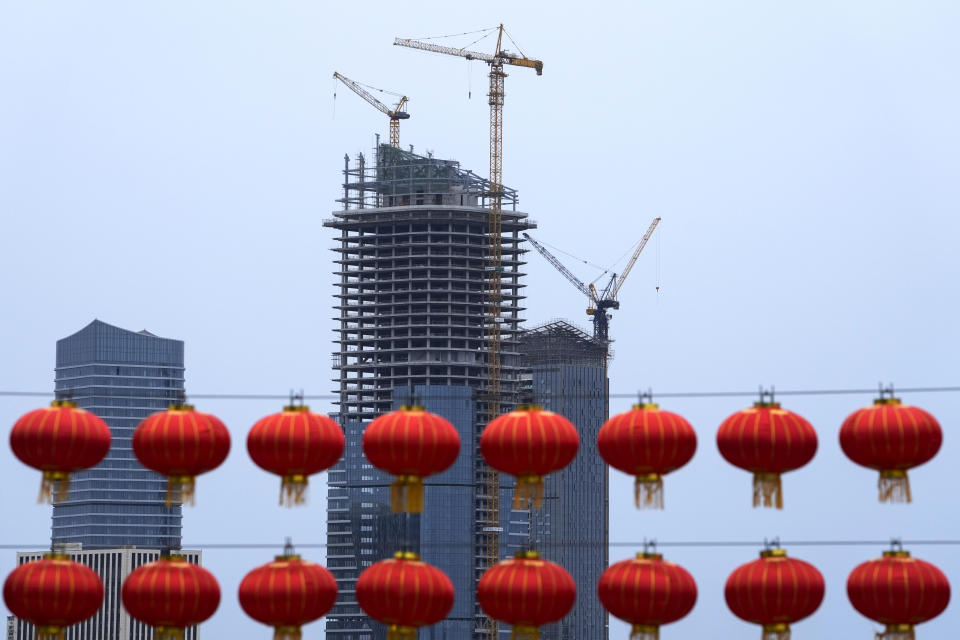 Red lanterns hang in front of a commercial office buildings under construction in Tongzhou, outskirts of Beijing, Monday, Oct. 4, 2021. China’s economy is losing steam as President Xi Jinping's government cracks down on corporate debt and energy use in pursuit of more stable, sustainable growth. (AP Photo/Andy Wong)