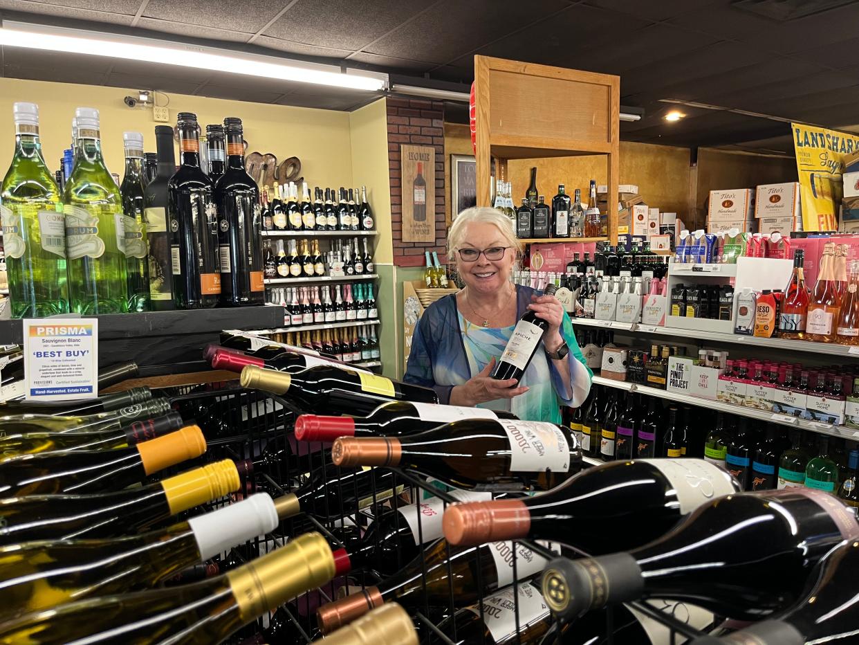 Local wine sommelier Katherine Powell selects a bottle of wine at Bartlesville Wines and Spirits.