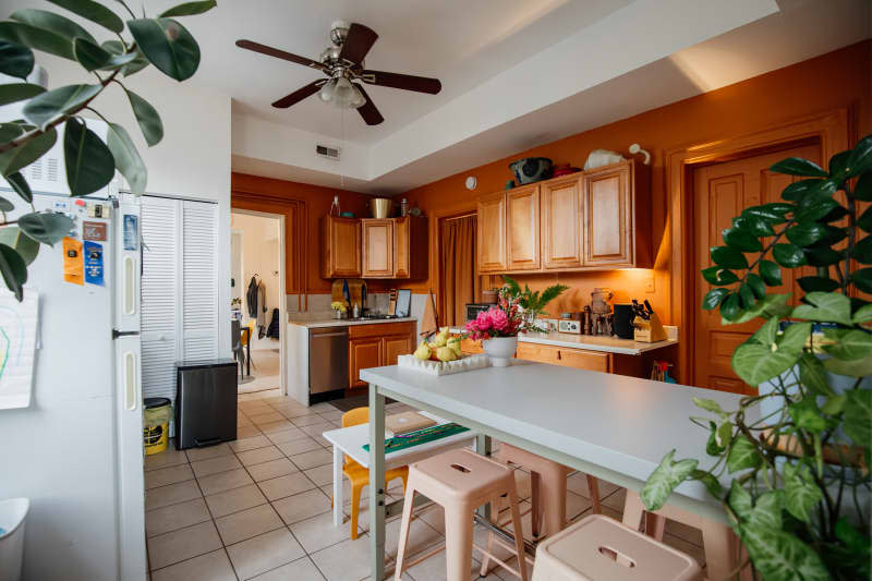 Rust painted kitchen with wooden cabinets.