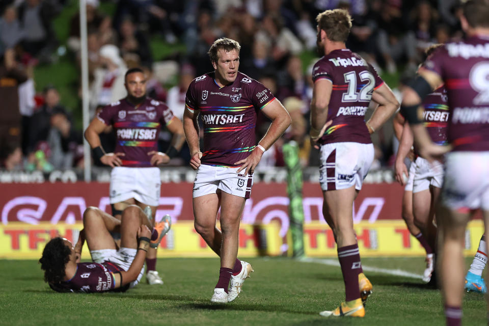 Jake Trbojevic (pictured middle) looks deflated after the Manly Sea Eagles concede a try against the Roosters.