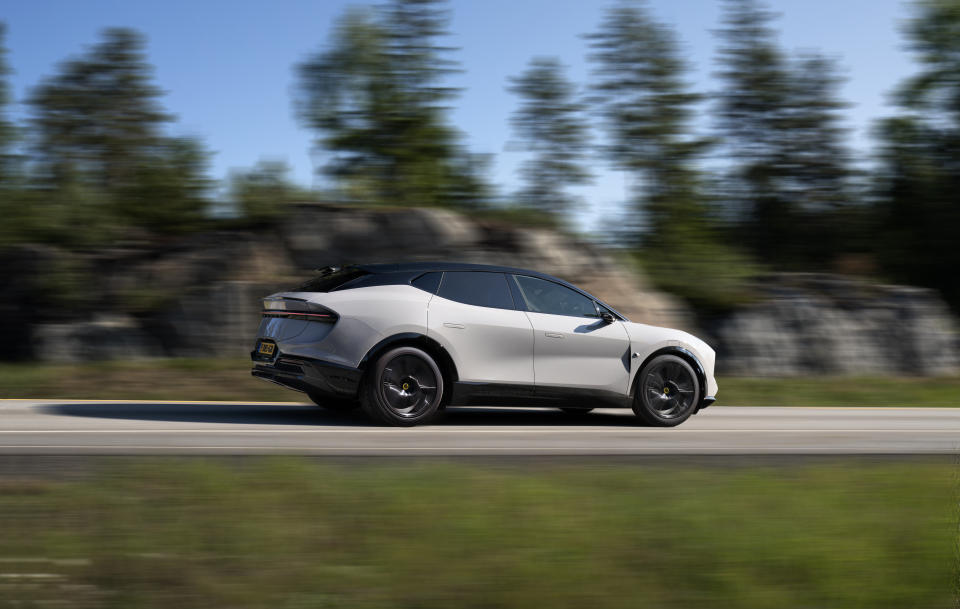 Image of a gray Lotus Eletre driving along a country road.