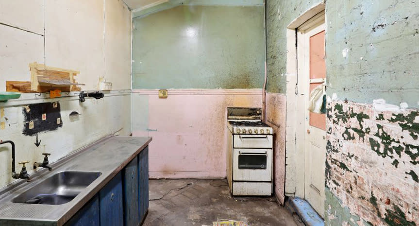 A rundown kitchen is pictured in a Waterloo home in Sydney.