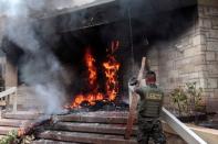 A soldier stands next to burning tires after a demonstration against government privatisation plans in healthcare and education in Tegucigalpa