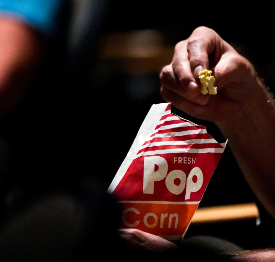 An audience member eats popcorn during the Lakota Board of Education meeting on Monday, Oct. 2, 2023, at the Lakota East Freshman Auditorium in Liberty Township. This is the first time the board is meeting since a judge ordered board member Darbi Boddy not to be within 500 feet of fellow board member Isaac Adi, due to Adi filing a protective order.