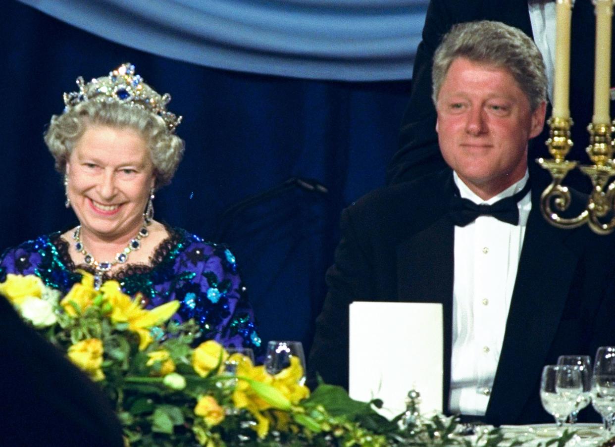 In this June 4, 1994 file photo, Britain's Queen Elizabeth smiles, as she sits alongside President Bill Clinton at a dinner in the Guildhall in Portsmouth, England.