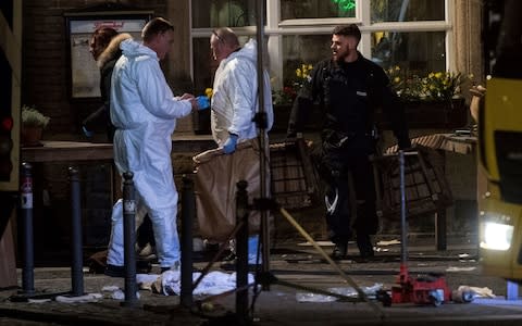 Forensic experts work at the scene on Saturday - Credit: David Young/dpa via AP