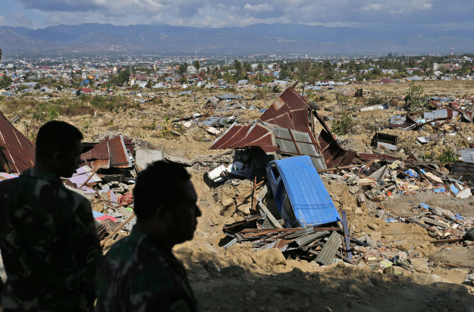 In this Saturday, Oct. 6, 2018, photo, soldiers survey the damage at Balaroa neighborhood which was wiped out by earthquake-triggered liquefaction in Palu, Central Sulawesi, Indonesia. Following the 7.5 magnitude earthquake on Sept. 28, the ground in the area simply lost its strength and turned to mush beneath people's feet, creating mud that acted like quicksand. Humans, houses, cars, and streets were sucked down and covered by a thick carpet of what _ just seconds earlier _ had been solid earth. (AP Photo/Dita Alangkara)