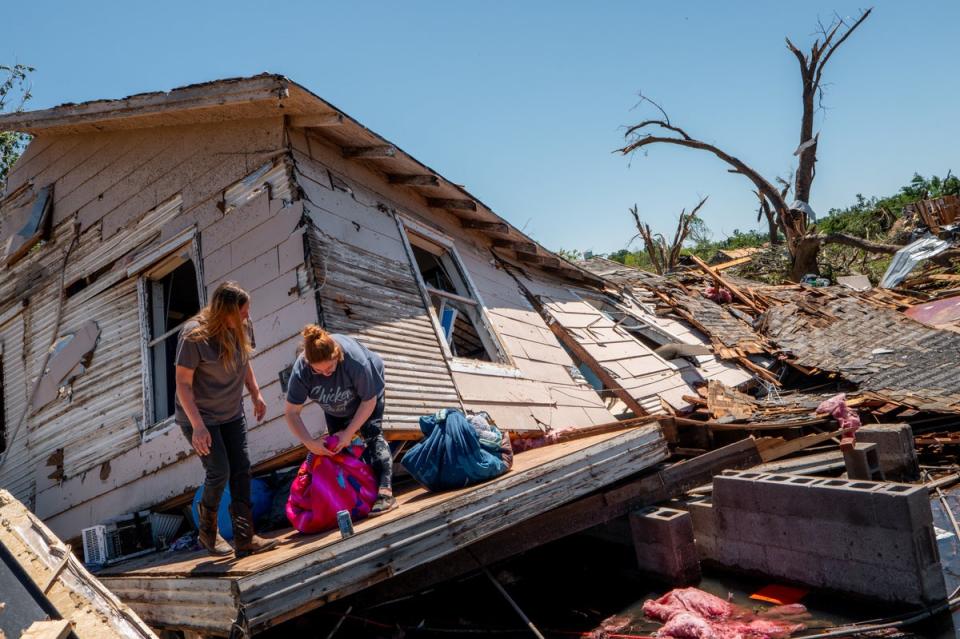 A family sift through and recover lost items after their home was struck by a tornado (Getty)