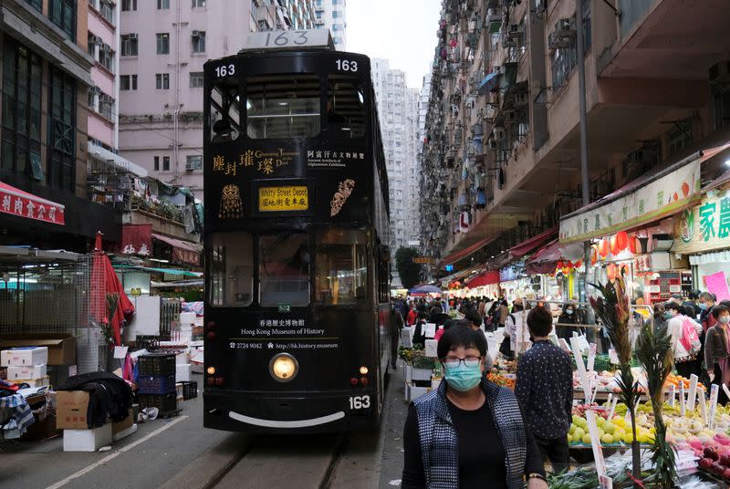 People wear masks as they walk at a marketplace in downtown following the outbreak of a new coronavirus, in Hong Kong