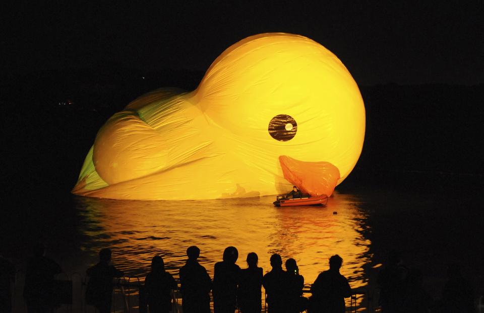 People observe as a Rubber Duck by Dutch conceptual artist Florentijn Hofman is being inflated on a lake at the Summer Palace in Beijing