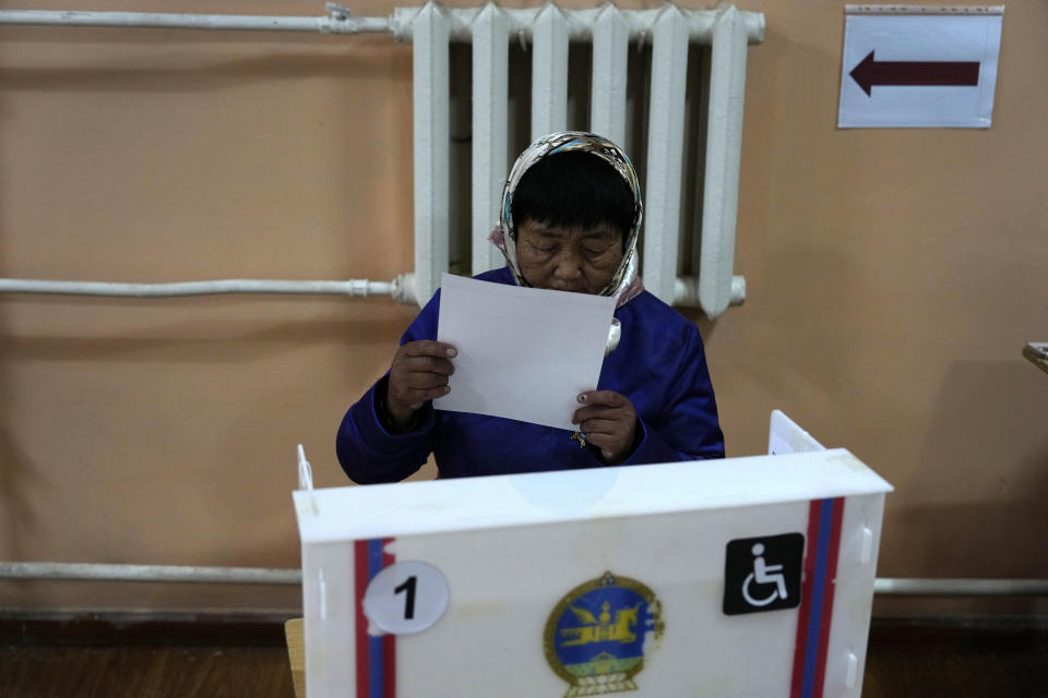 A voter examines her vote at a polling station in the Ger District on the outskirts of Ulaanbaatar, Mongolia, Friday, June 28, 2024. Voters in Mongolia are electing a new parliament on Friday in their landlocked democracy that is squeezed between China and Russia, two much larger authoritarian states. (AP Photo/Ng Han Guan)