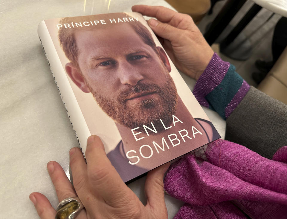 A woman holds a copy of "En La Sombra" (In the Shadow), the Spanish translation of Prince Harry's memoir, "Spare," in Barcelona, Spain, Thursday Jan. 5, 2023. Prince Harry alleges in a much-anticipated new memoir, due to be published next week, that his brother Prince William lashed out and physically attacked him during a furious argument over the brothers' deteriorating relationship. (AP Photo)