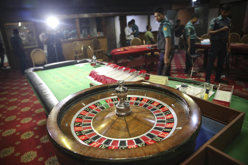 In this Sept. 22, 2019, photo, police officers inspect seized gambling equipment at Victoria Sporting Club in Dhaka, Bangladesh. Security officials in Bangladesh are on the hunt for cash, gold and illicit weapons in a crackdown Prime Minister Sheikh Hasina ordered on illegal casinos, rooting out corruption among political elites that critics say has been allowed to flourish in a troubled democracy with no effective opposition. (AP Photo/Mahmud Hossain Opu)