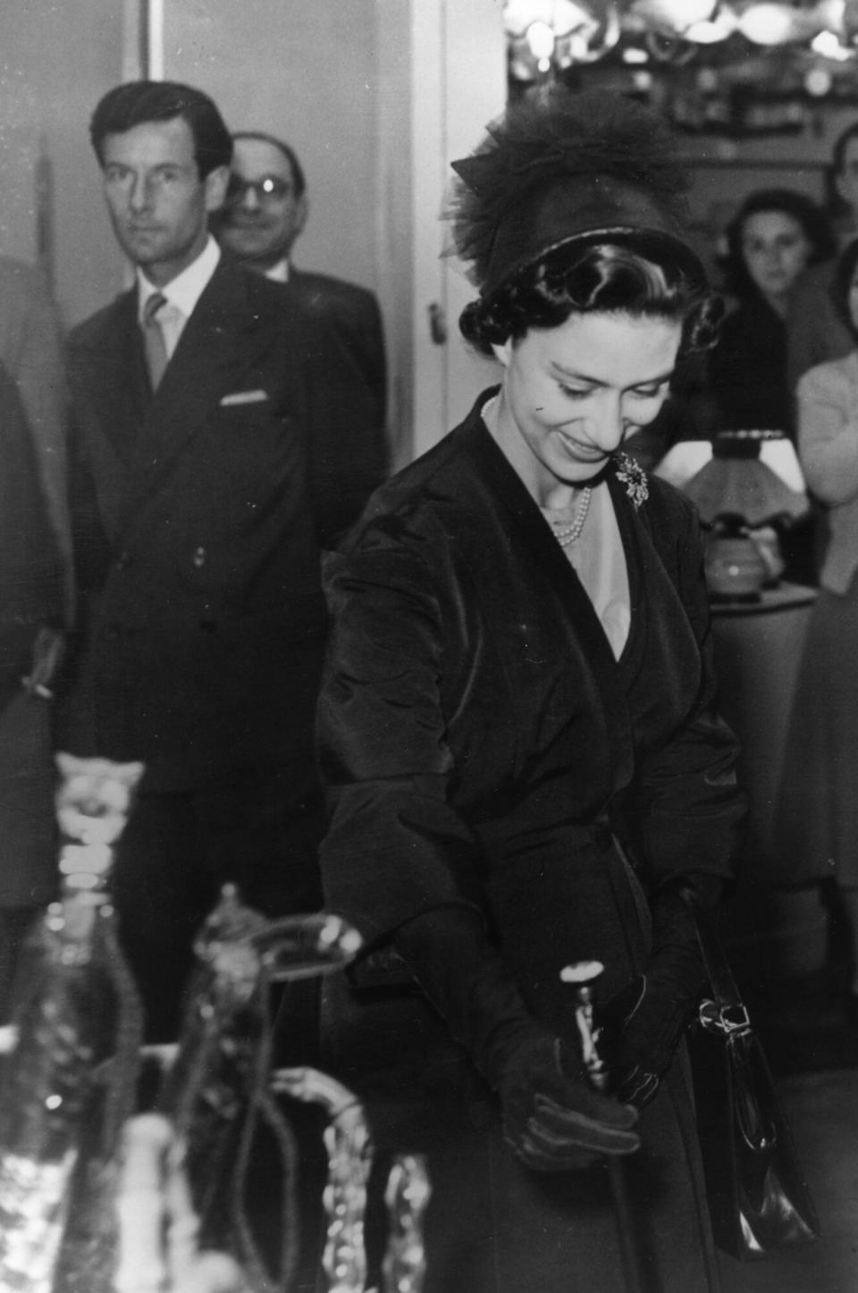Princess Margaret (1930 - 2002) at the British Industries Fair at Olympia, London. Captain Peter Townsend, the divorced Royal Air Force captain she was later refused permission to marry, stands in the background