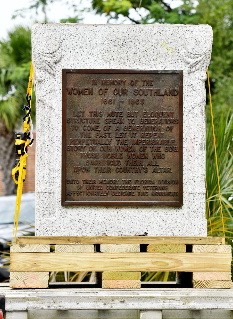 The pedestal and commemorative plaque that held the bronze statue of a woman reading to two children is strapped to the bed of a flatbed truck after being removed from the "Women of the Southland" monument in Springfield Park on Wednesday.