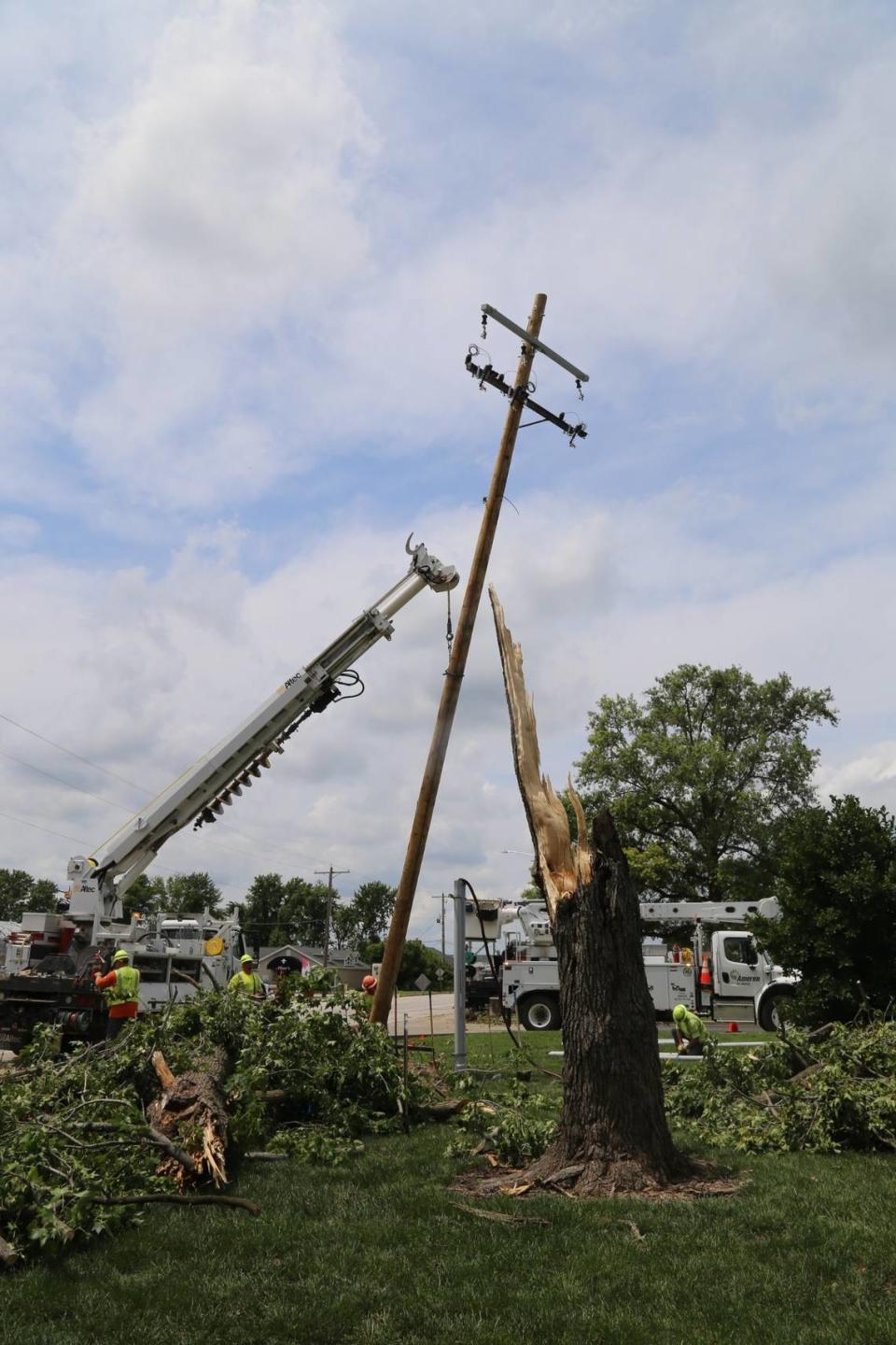 A four-man Ameren Illinois line crew from Centralia assists with restoration efforts in New Baden along Hanover Street (Illinois Route 161) and in front of Zion United Church of Christ. Winds toppled a tree that fell into a nearby utility pole and snapped the pole. Two different storms blew through portions of Ameren Illinois service territory, July 15-16. The company restored power to 92,000 customers in 36 hours.