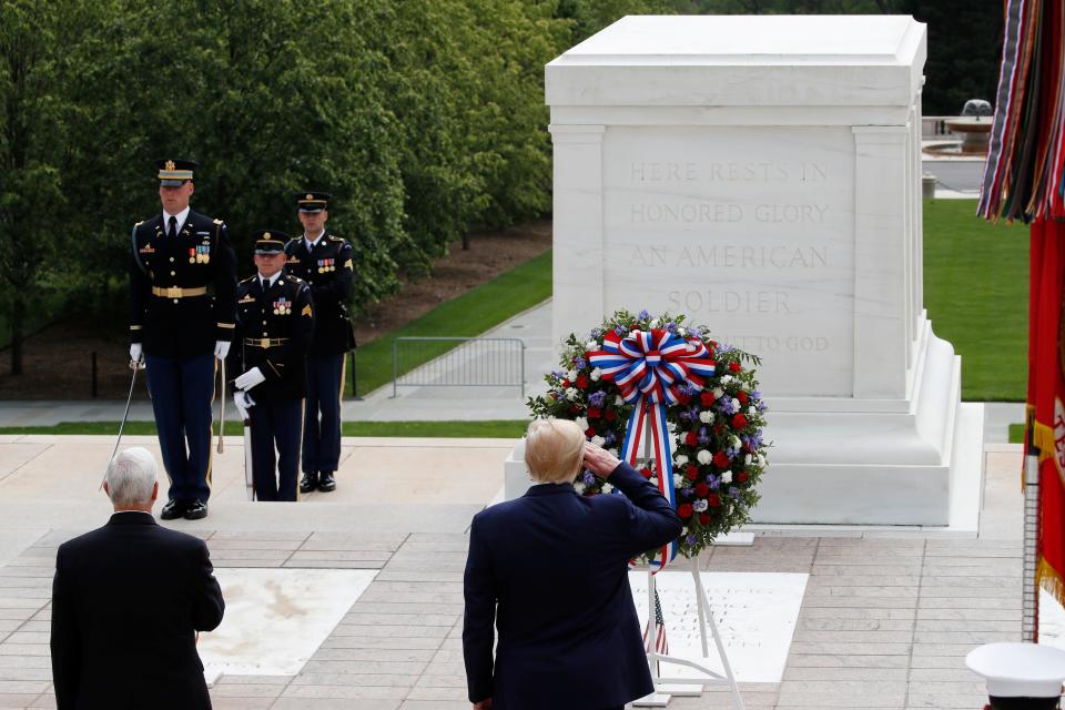 President Donald Trump salutes at the Tomb of the Unknown Soldier in Arlington National Cemetery, in honor of Memorial Day, Monday, May 25, 2020, in Arlington, Va., with Vice President Mike Pence.