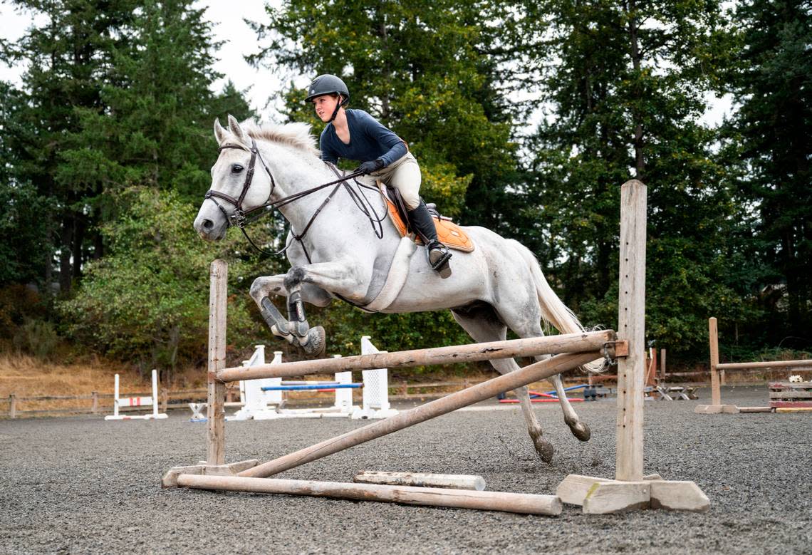 Emerald Ridge High School sophomore Emily Bingham practices jumps with her horse, Q It Up, at Signature West Farms LLC in Spanaway, Wash. on Sept. 22, 2022. Bingham was nominated by the Washington State Hunter Jumper Association for the Marshall & Sterling Insurance/USHJA National Championships, a competition for riders in the country to earn national titles.