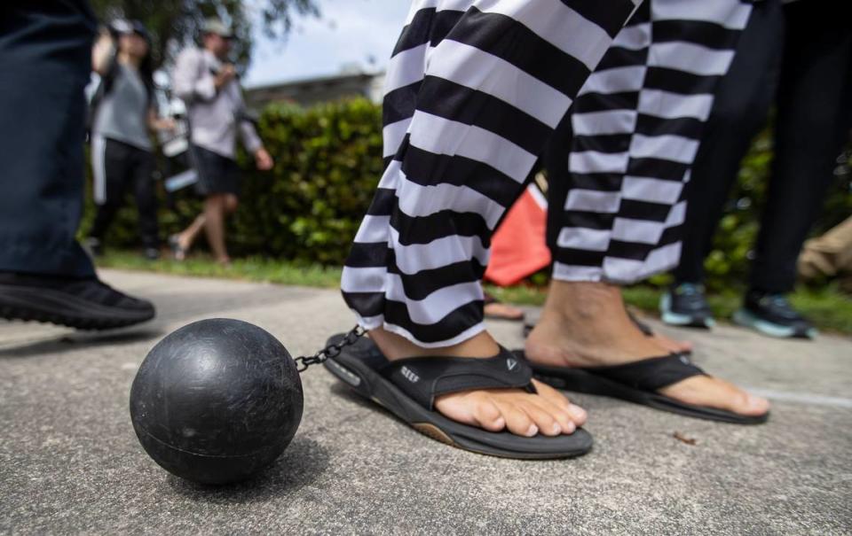 Anti-Trumper Domenic Santana wears a plastic ball and chain as he walks near the entrance of Trump National Doral on Monday, June 12, 2023, in Doral, Fla.