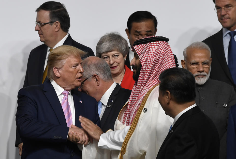 FILE - In this June 28, 2019, file photo, President Donald Trump, left, shakes hands with Saudi Arabia's Crown Prince Mohammed bin Salman, as they gather for a group photo at the G-20 summit in Osaka, Japan. The Nov. 21-22, 2020, Group of 20 summit, hosted by Saudi Arabia, will be held online this year because of the coronavirus. The gathering of leaders of the world’s preeminent rich and developing nations will not be an opportunity for kings, presidents and prime ministers to conduct the intimate diplomacy of closed-door meetings or pose for memorable photo-ops. (AP Photo/Susan Walsh, File)