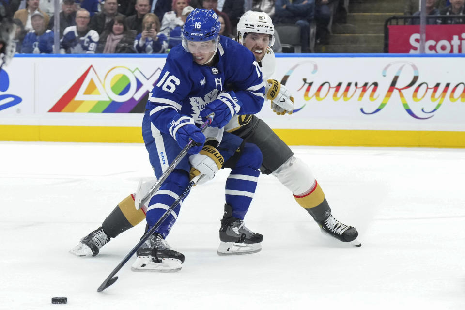 Toronto Maple Leafs' Mitchell Marner (16) protects the puck from Vegas Golden Knights' Shea Theodore during the second period of an NHL hockey game in Toronto, on Tuesday, Feb. 27, 2024. (Chris Young/The Canadian Press via AP)