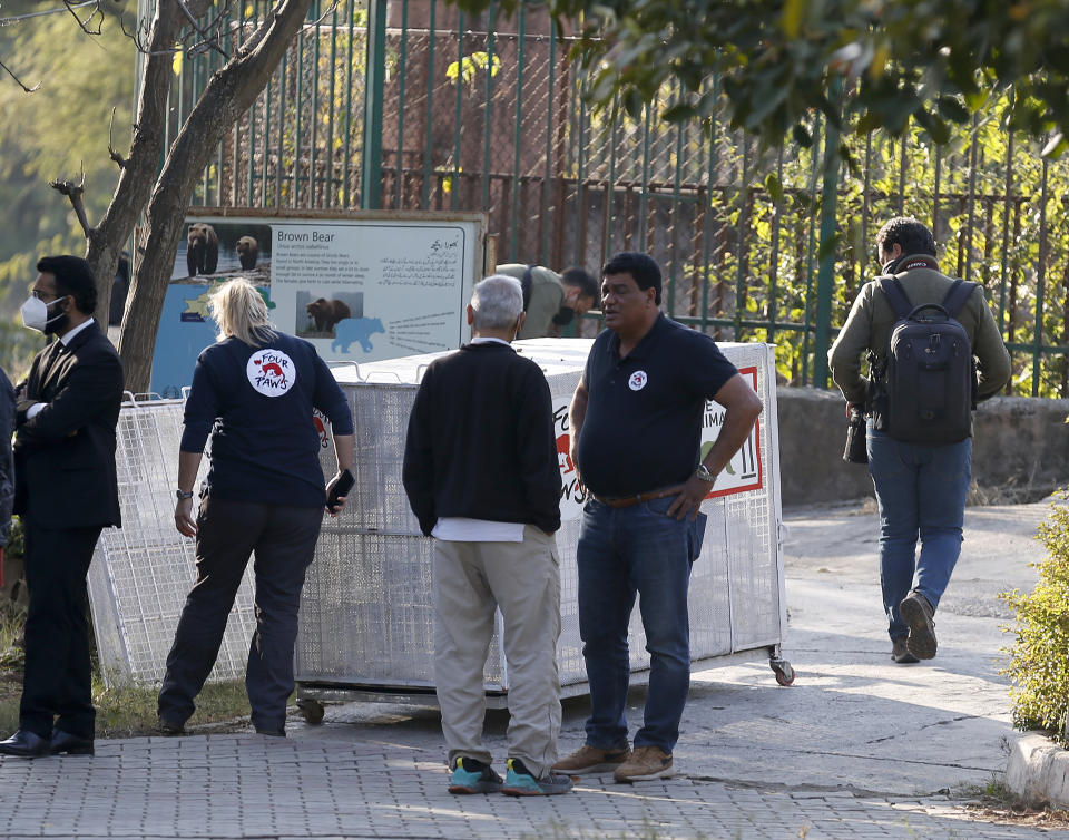 Dr. Amir Khalil, second right, a veterinarian from the international animal welfare organization Four Paws, talks to his team next to a crate to be used for transporting a sick brown bear, at the Marghazar Zoo, in Islamabad, Pakistan, Wednesday, Dec. 16, 2020. A pair of sick and neglected dancing Himalayan brown bears will leave Islamabad's notorious zoo Wednesday for a sanctuary in Jordan, closing down a zoo that once housed 960 animals. The Marghazar Zoo's horrific conditions gained international notoriety when Kaavan, dubbed the world's loneliest elephant, grabbed headlines and the attention of iconic American entertainer Cher. (AP Photo/Anjum Naveed)