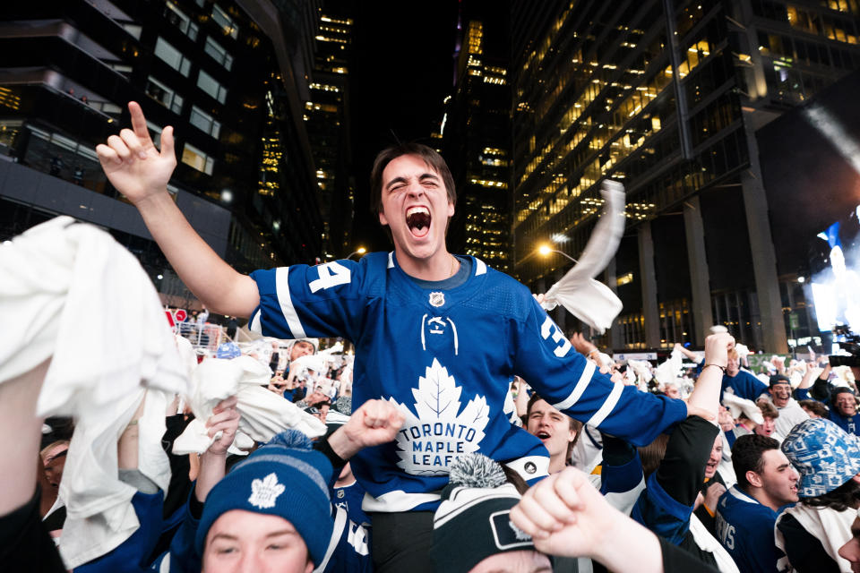 Fans react after a Toronto Maple Leafs goal while watching the Maple Leafs play the Boston Bruins in Game 6 of first-round NHL hockey playoff series on a videoscreen outside Scotiabank Arena in Toronto, Thursday, May 2, 2024. (Arlyn McAdorey/The Canadian Press via AP)