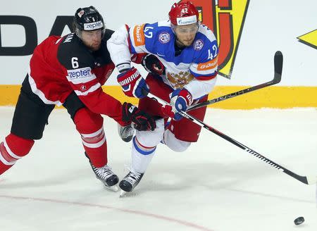 Canada's Jake Muzzin fights for the puck with Russia's Artyom Anisimov (R) during their Ice Hockey World Championship final game against Russia at the O2 arena in Prague, Czech Republic May 17, 2015. REUTERS/Laszlo Balogh