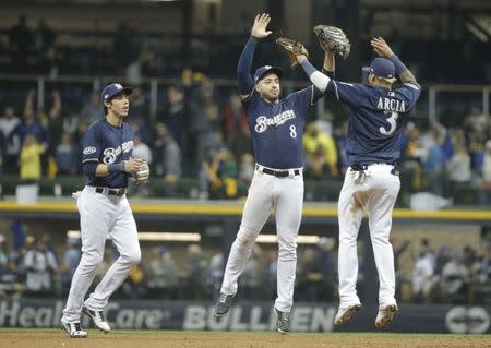 Oct 12, 2018; Milwaukee, WI, USA; Milwaukee Brewers right fielder Christian Yelich (22) and left fielder Ryan Braun (8) and shortstop Orlando Arcia (3) celebrate after defeating the Los Angeles Dodgers in game one of the 2018 NLCS playoff baseball series at Miller Park. Mandatory Credit: Jon Durr-USA TODAY Sports