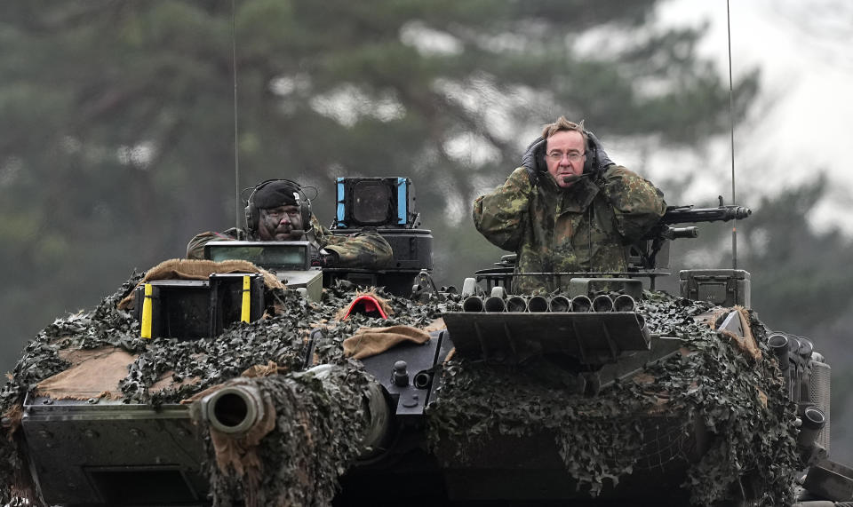 FILE -- German Defense Minister Boris Pistorius, right, sits on a Leopard 2 tank at the Bundeswehr tank battalion 203 at the Field Marshal Rommel Barracks in Augustdorf, Germany, Wednesday, Feb. 1, 2023. Nearly a year after Chancellor Olaf Scholz declared Russia’s invasion of Ukraine a 'turning point' that would trigger German weapons supplies to a country at war and a massive increase in spending on the German armed forces, his country’s military turnaround still has a long way to go. (AP Photo/Martin Meissner, file)