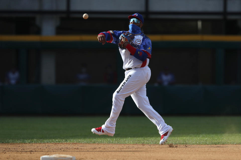 Robinson Canó, de las Águilas Cibaeñas, de la República Dominicana, realiza un lanzamiento a primera para sacar un out frente a Puerto Rico en el segundo inning del partido por la Serie del Caribe, en el estadio Teodoro Mariscal de Mazatlán, México, el domingo 31 de enero de 2021. (AP Foto/Moisés Castillo)