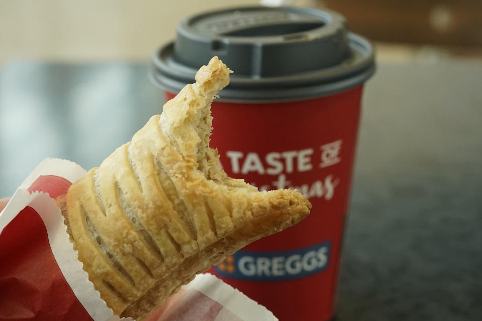 A sausage roll and cup of coffee