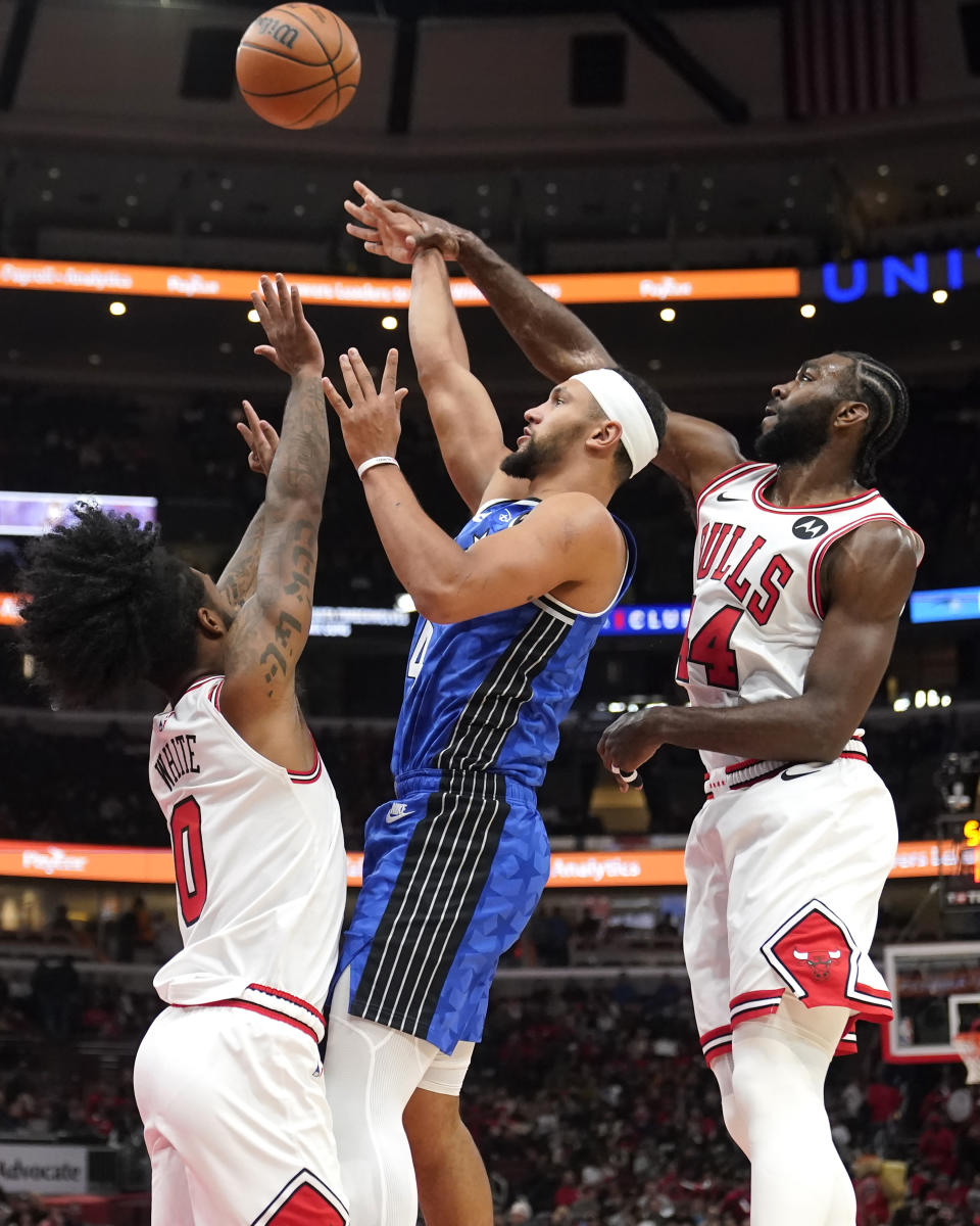 Orlando Magic's Jalen Suggs, center, shoots between Chicago Bulls' Coby White (0) and Patrick Williams (44) during the first half of an NBA basketball game Wednesday, Nov. 15, 2023, in Chicago. (AP Photo/Charles Rex Arbogast)