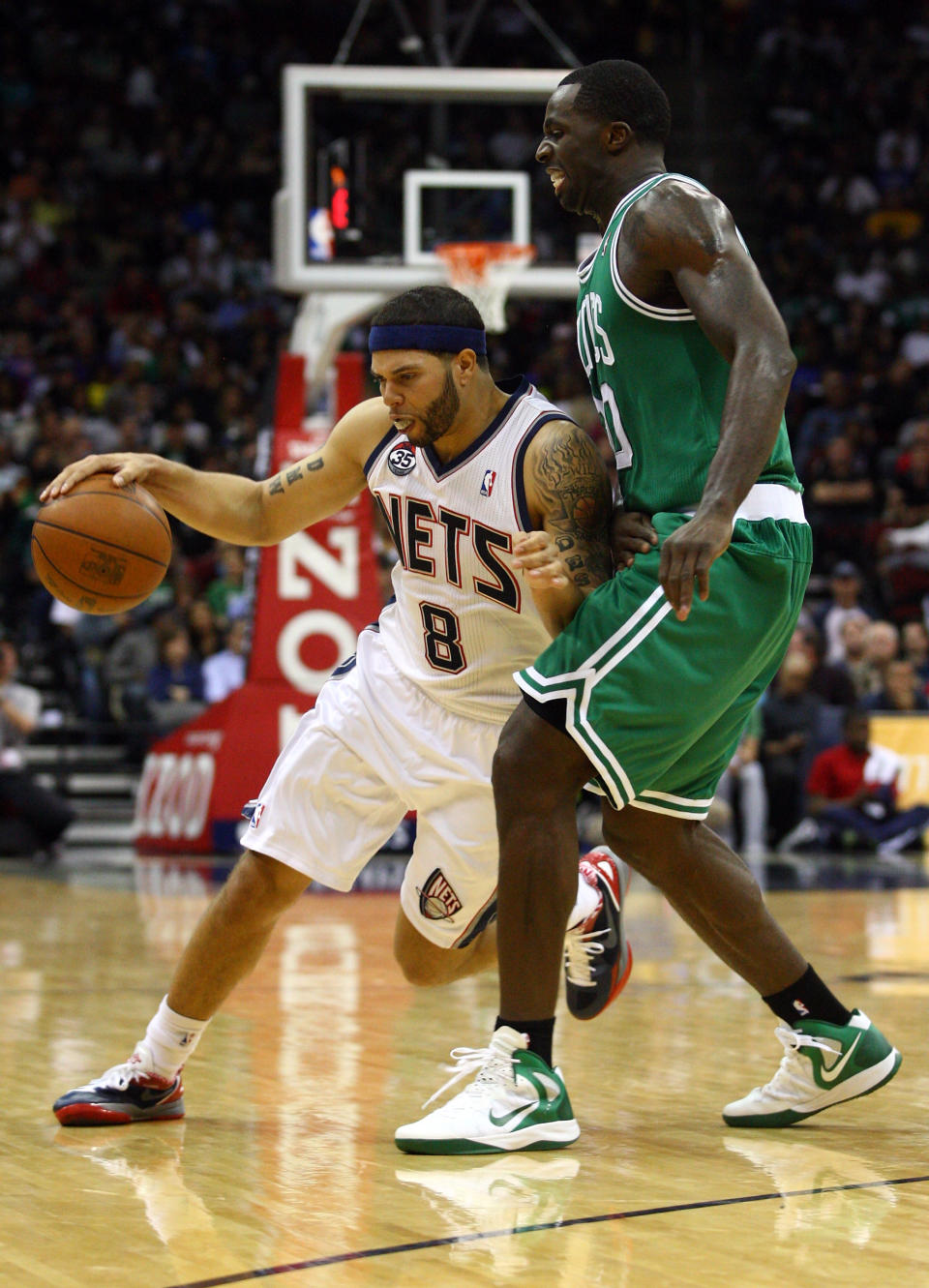 NEWARK, NJ - APRIL 14: Deron Williams #8 of the New Jersey Nets drives in the secon dhalf against Brandon Bass #30 of the Boston Celtics at Prudential Center on April 14, 2012 in Newark, New Jersey. NOTE TO USER: User expressly acknowledges and agrees that, by downloading and or using this photograph, User is consenting to the terms and conditions of the Getty Images License Agreement. (Photo by Chris Chambers/Getty Images)