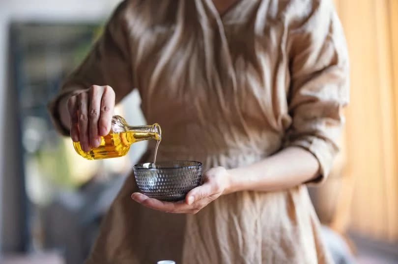 Woman pouring oil into a bowl