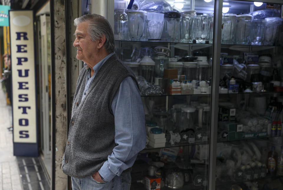 In this Nov. 4, 2019 photo, retired Jose Urzua, 74, poses for a photo at his work at a store that sells spare parts for blenders, in downtown Santiago, Chile. The protests in Chile include struggling retirees as well as others seeking better salaries, subsidized housing, a decrease in the cost of medicine and a new constitution. (AP Photo/Esteban Felix)