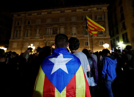 A man wears an Estelada, Catalan separatist flag, as protesters gathered outside the regional government headquarters after Spain's High Court jailed the leaders of two of the largest separatist organizations, the Catalan National Assembly's Jordi Sanchez and Omnium's Jordi Cuixart, in Barcelona, Spain, October 16, 2017. REUTERS/Gonzalo Fuentes