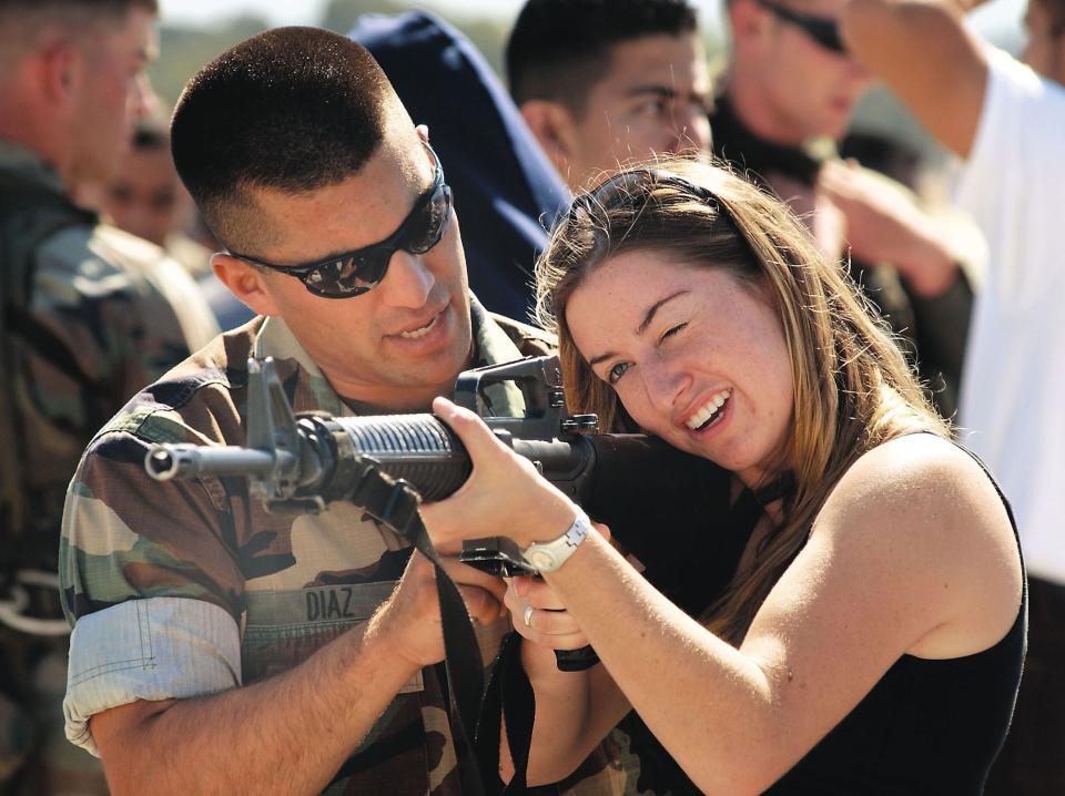 A woman is instructed how to handle an M16 rifle by Marine Sergeant Richard Diaz in California in 2002.