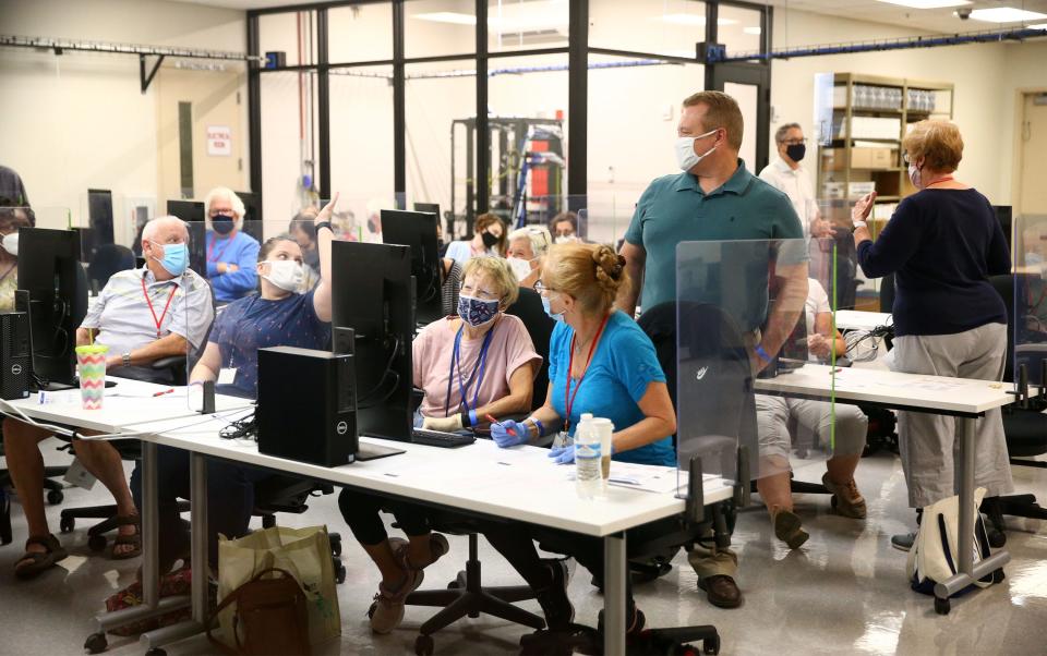 A bipartisan board works on electronic adjudication on mail-in ballots that are tabulated at the Maricopa County Elections Headquarters in Phoenix on Oct. 20, 2020.