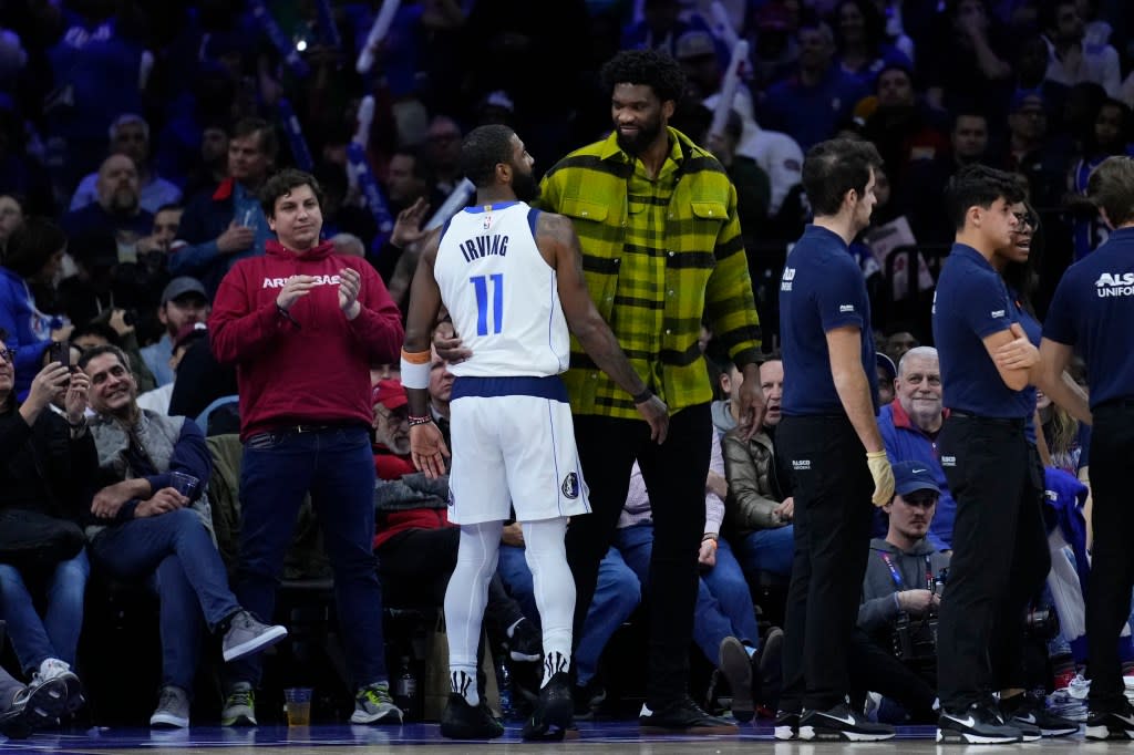 Philadelphia 76ers’ Joel Embiid, center right, and Dallas Mavericks’ Kyrie Irving (11) meet during the second half of an NBA basketball game, Monday, Feb. 5, 2024, in Philadelphia. (AP Photo/Matt Rourke)