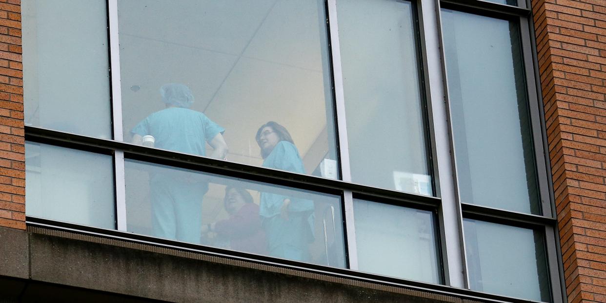 FILE PHOTO: Employees dressed in scrubs talk with each other at Providence Regional Medical Center after a spokesman from the U.S. Centers for Disease Control and Prevention (CDC) said a traveler from China has been the first person in the United States to be diagnosed with the Wuhan coronavirus, in Everett, Washington, U.S. January 21, 2020.  REUTERS/Lindsey Wasson