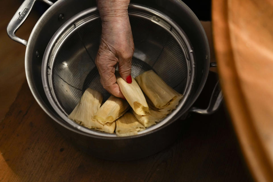 Noelia Sanchez and her mother Aurora Sandoval prepare tamales at the family home Tuesday, Dec. 26, 2023, in Chicago. When she was 1, Sanchez and her mother, who had no work documents, were rounded up with dozens of other immigrants in a Texas town near the border. The U.S.-born child and her mother were forced to go to Mexico along with hundreds of thousands of other people. (AP Photo/Erin Hooley)