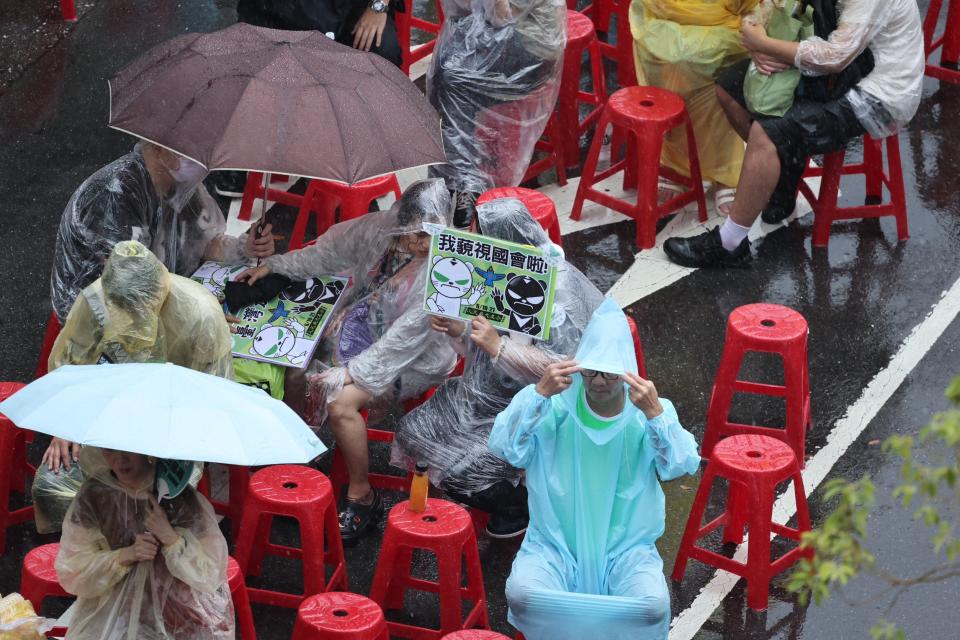 不少青鳥運動支持者頂著暴雨坐在現場聽講。林啟弘攝