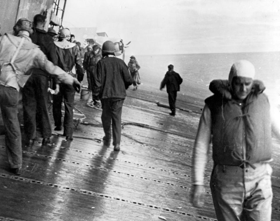 FILE - This June 4, 1942 photo provided by the U.S. Navy shows a scene on the flight deck of USS Yorktown shortly after it was hit by two Japanese aerial torpedoes. Men are balancing themselves on the listing deck as they prepare to abandon ship. Researchers scouring the world's oceans for sunken World War II ships are honing in on debris fields deep in the Pacific. A research vessel called the Petrel is launching underwater robots about halfway between the U.S. and Japan in search of warships from the Battle of Midway. (U.S. Navy via AP, File)