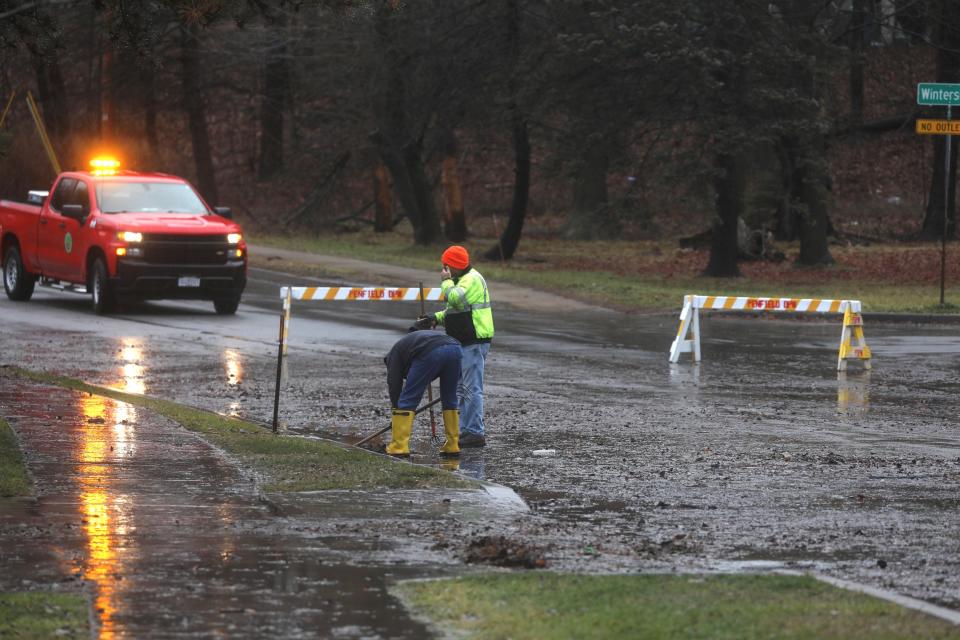 Town of Penfield employees clean clogged sewer drains that allowed rain to collect and flood a portion of Panorama Trail near Penfield Road in Penfield.