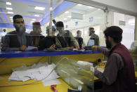 Afghan men wait to receive their passports from the main post office in the city of Kabul, Afghanistan, Wednesday, July 3, 2024. In parts of Afghanistan where there are no street names or house numbers, utility companies and their customers have adopted a creative approach for connecting. They use mosques as drop points for bills and cash, a "pay and pray" system. (AP Photo/Siddiqullah Alizai)