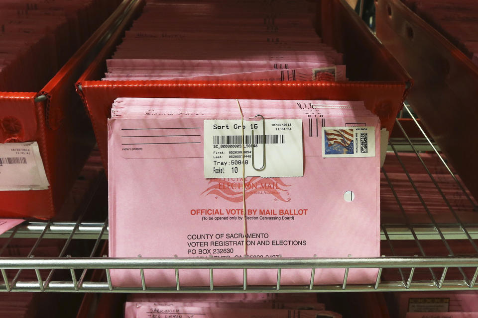 FILE - In this Oct. 22, 2018, file photo, mail-in ballots are placed in bins to be processed after arriving at the Sacramento County Registrar of Voters in Sacramento, Calif. Over 100,000 mail-in ballots were rejected by election officials in California's March 2020 presidential primary, highlighting a glaring gap in the effort to ensure every vote is counted as a national dispute rages over the integrity of vote-by-mail elections. (AP Photo/Rich Pedroncelli, File)