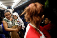 A Central American migrant, moving in a caravan through Mexico and traveling to request asylum in U.S, holds a baby inside a bus before her travels from Hermosillo to Mexicali, in Sonora state, Mexico April 23, 2018. REUTERS/Edgard Garrido