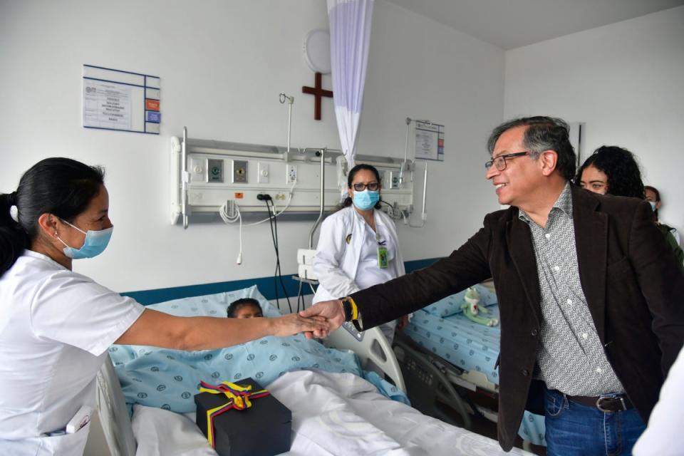 Colombia's President Gustavo Petro greets a nurse tending to one of the four Indigenous children who survived an Amazon plane crash that killed three adults and then braved the jungle for 40 days before being found alive (Cesar Carrion)