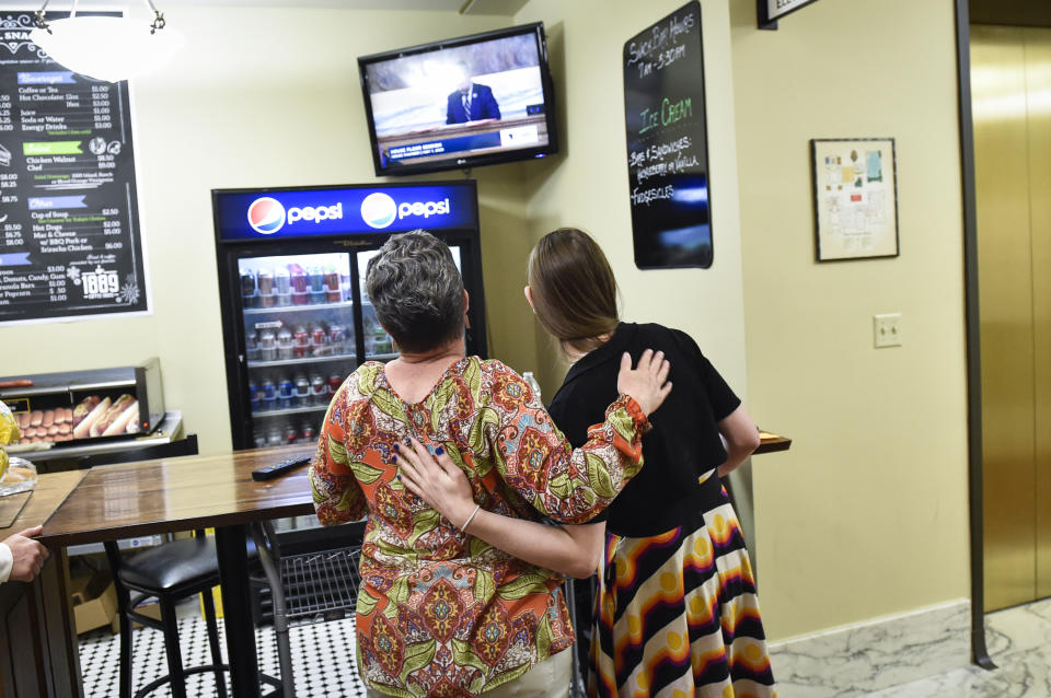 Rep. Zooey Zephyr, D-Missoula, hugs Shani Henry as she works from the lunch counter outside House of Representatives chamber in the Montana State Capitol in Helena, Mont. on Monday, May 1, 2023. (Thom Bridge/Independent Record via AP)